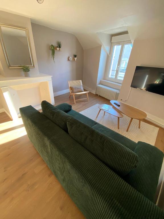 un salon avec un canapé vert et une table dans l'établissement Au cœur de Blois, à Blois