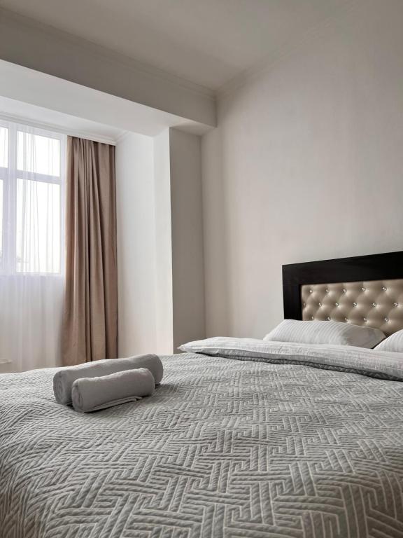 - une chambre avec un grand lit et une grande fenêtre dans l'établissement Hyat apartment, à Bishkek