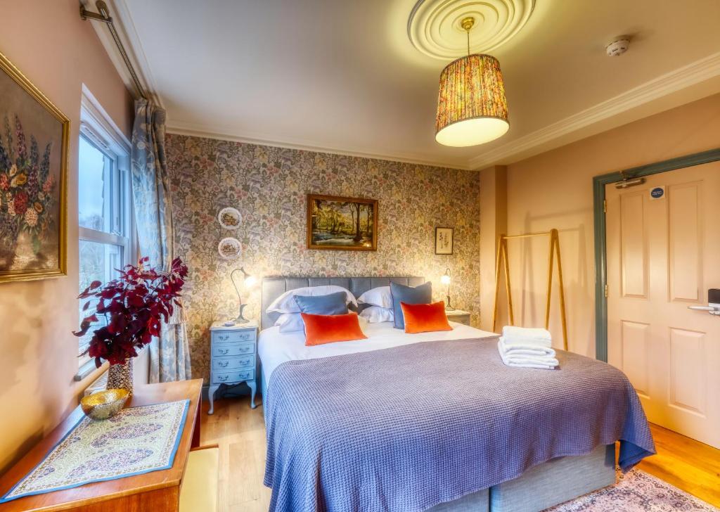 um quarto com uma cama grande e almofadas laranja em The Bluebell em Bath