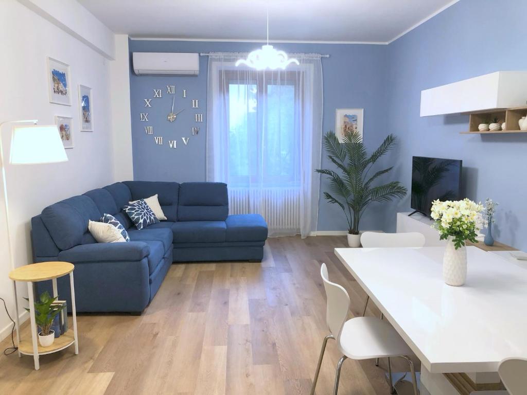 ein Wohnzimmer mit einem blauen Sofa und einem Tisch in der Unterkunft Amalphia Home in Salerno