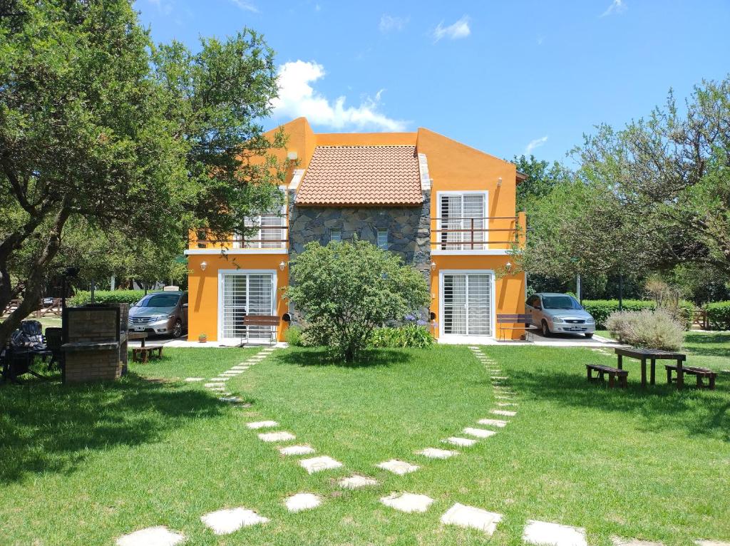 a house with a walkway in the yard at Cabañas Rincon Verde in Merlo