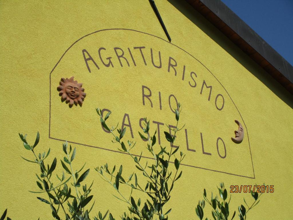 un cartello sul lato di un edificio giallo di Agriturismo Rio Castello a Marina dʼAndora