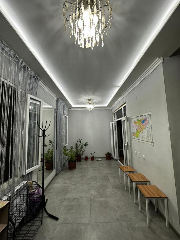 a hallway with benches and a chandelier at Guest house Family7 in Osh