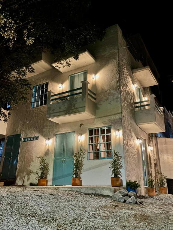 un edificio con una porta blu e piante in vaso di Cabaña Villa Jardín - Aldea Doradal - Santorini Colombiano a Doradal