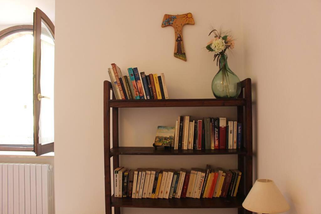 uma estante cheia de livros e um vaso de flores em Casa Balani em Assis