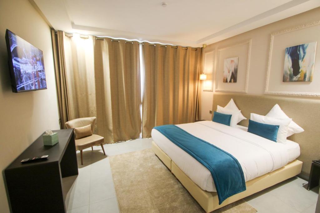 um quarto de hotel com uma cama grande e uma cadeira em Dakhla Boarding Hotel & Restaurant em Dakhla