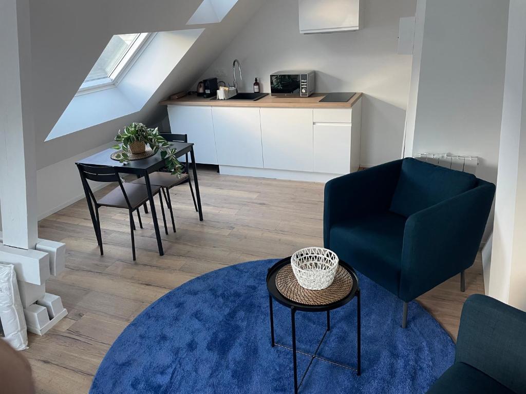 sala de estar con silla azul y mesa en Studio 302 - Hyper Centre - Intégralement rénové - Toutes commodités à pied, en Saint-Nazaire