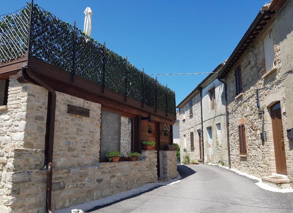 um beco num antigo edifício de pedra com vasos de plantas em IL BORGHETTO em San Sisto