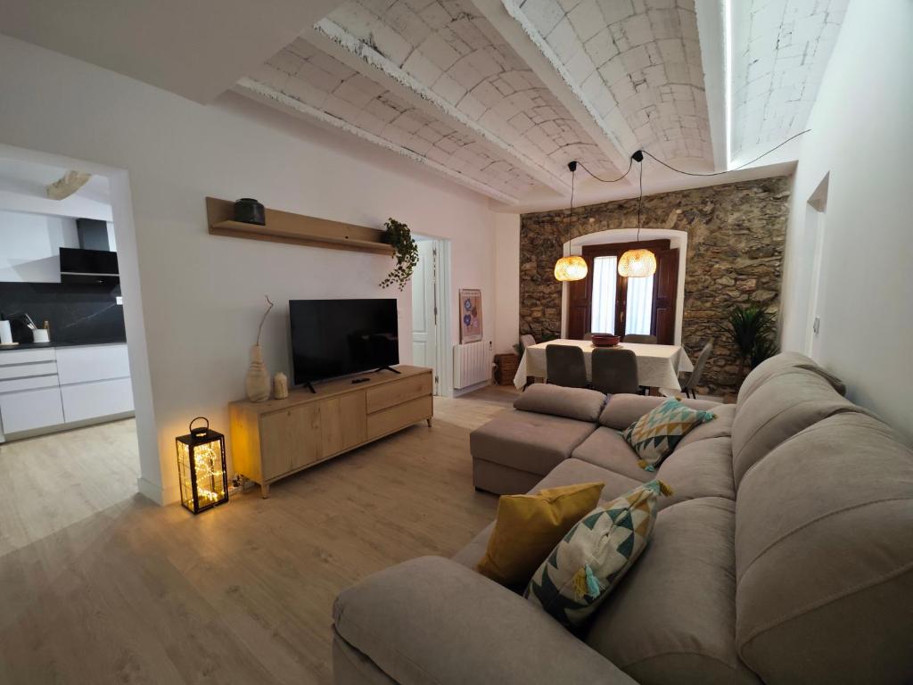 ein Wohnzimmer mit einem Sofa und einem TV in der Unterkunft Can Carisma in Camprodon