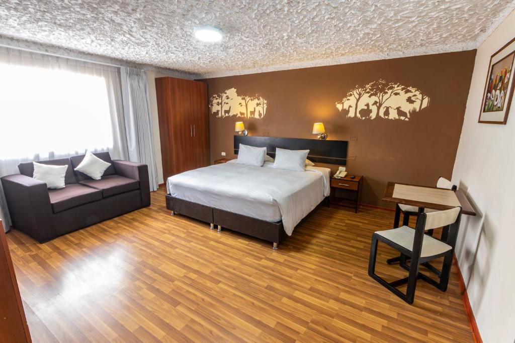 La Casona de Rimacpampa في كوسكو: غرفه فندقيه بسرير واريكه