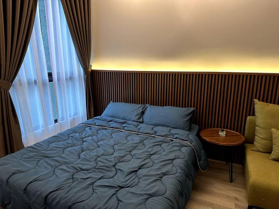 ein Schlafzimmer mit einem blauen Bett und einem Sofa in der Unterkunft New KL Bangsar South Hotel-styled Cozy Studio in Kuala Lumpur