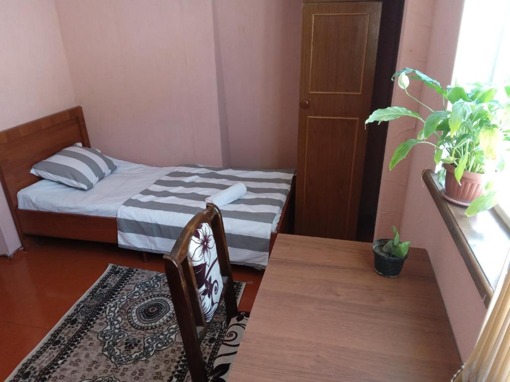 a small room with a bed and a table at Sayfi Guesthouse in Dushanbe