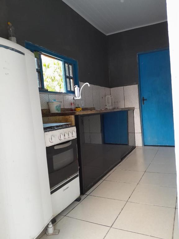 uma cozinha com um fogão e uma porta azul em Paz e lazer em Macaé