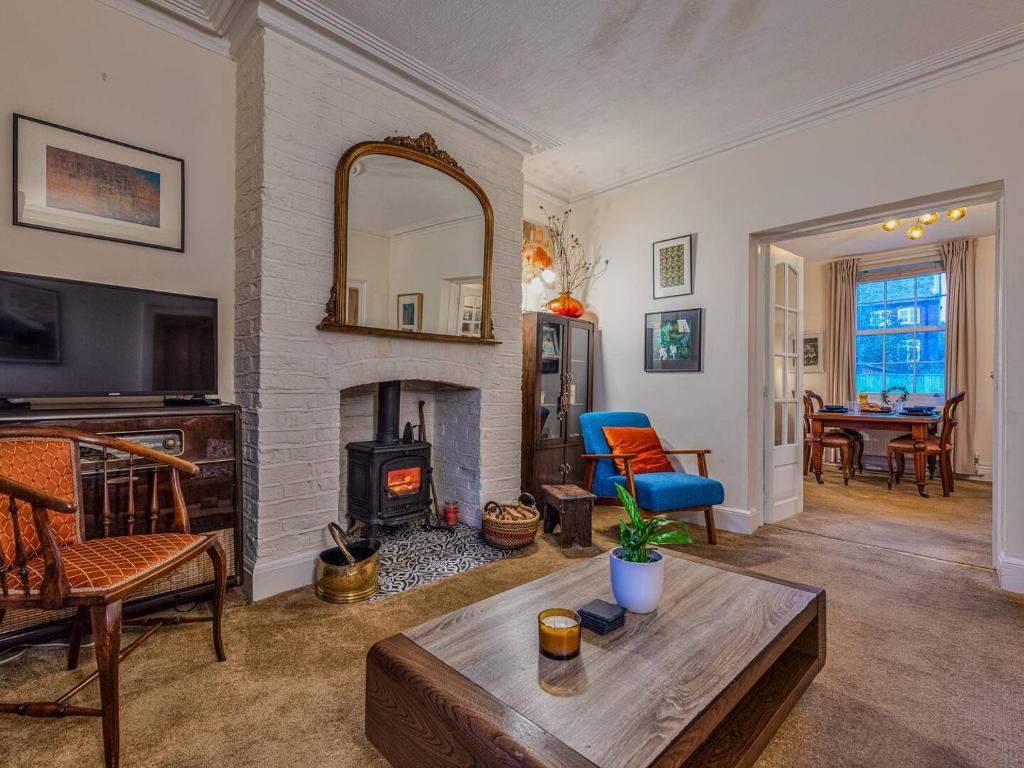 a living room with a fireplace and a table at Charming Victorian Hidden Gem - Pass the Keys in Market Drayton