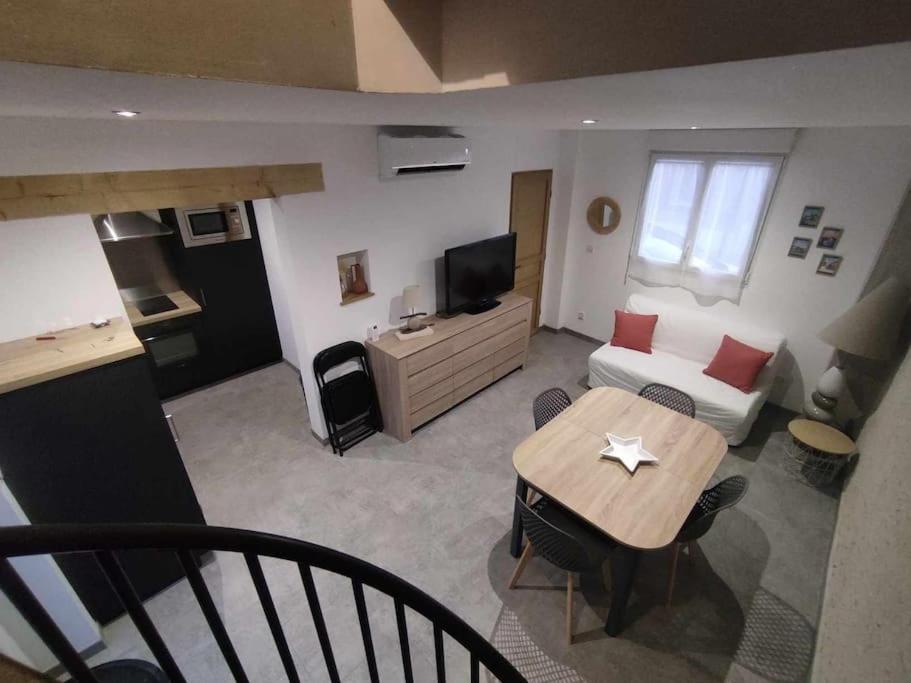 uma sala de estar com uma mesa e um sofá em Gîte Le Clos Controis em Contres