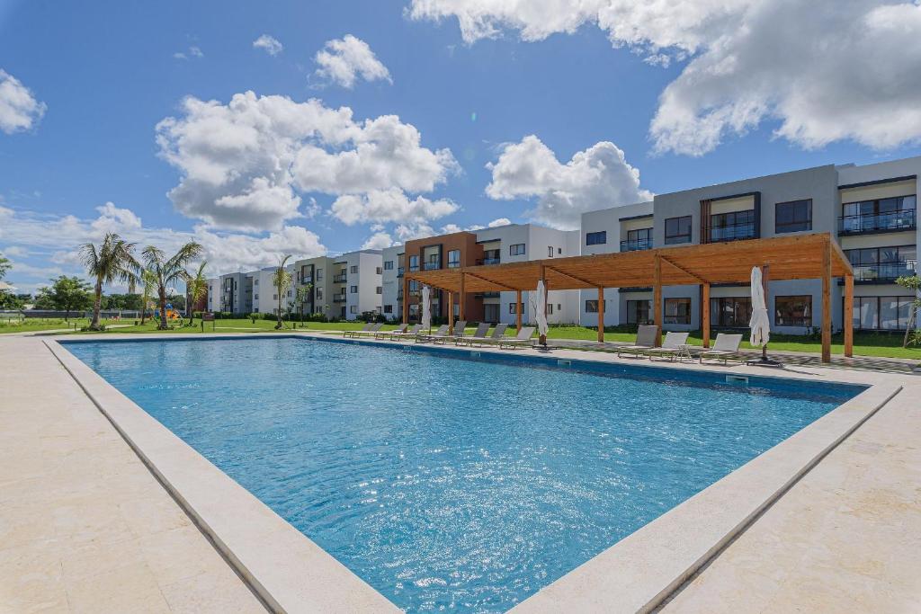 a swimming pool in front of a building at Apartamento vista a piscina, gym y cerca de playa in Punta Cana