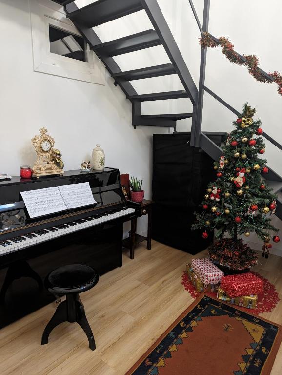 a christmas tree in a living room with a piano at Casa hierro in Vigo