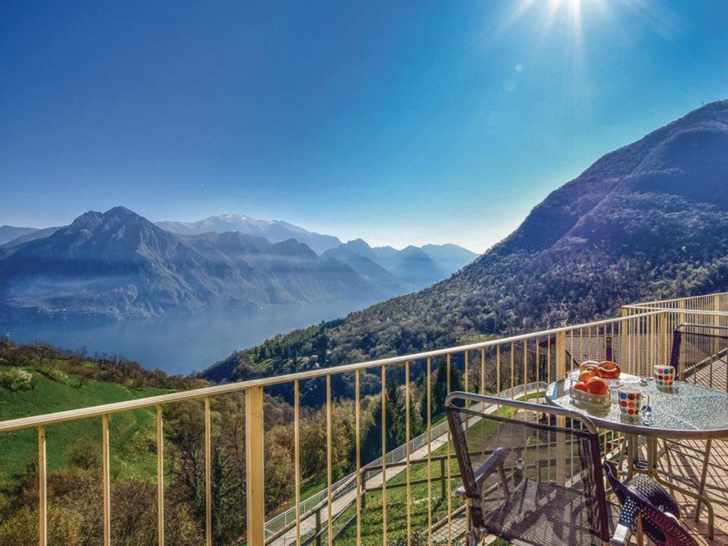 balcón con mesa y vistas a las montañas en Soffio Di Rugiada - spacious terrace with Lake view, en Fonteno
