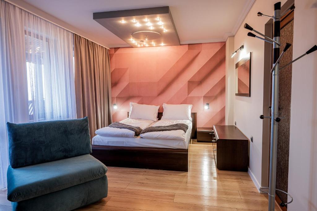 niewielka sypialnia z łóżkiem i krzesłem w obiekcie Villa Green Magic w mieście Szipka