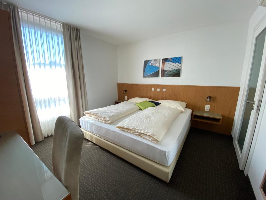 ein Hotelzimmer mit einem Bett und einem Fenster in der Unterkunft Businesshotel Lux in Luzern