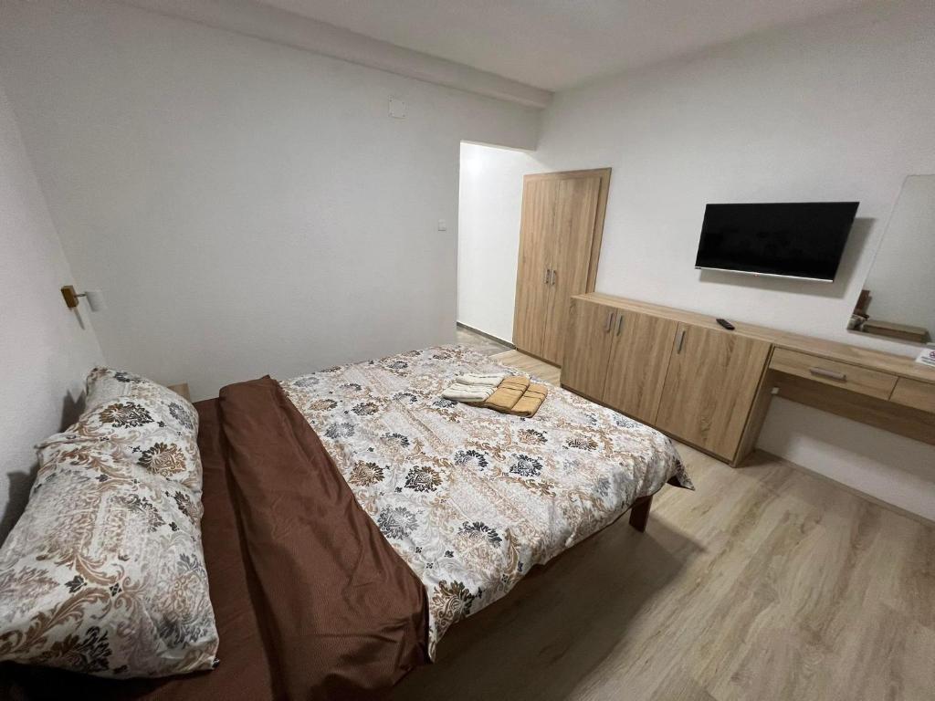 sypialnia z łóżkiem i telewizorem na ścianie w obiekcie Royal Stars Apartments w mieście Strumica