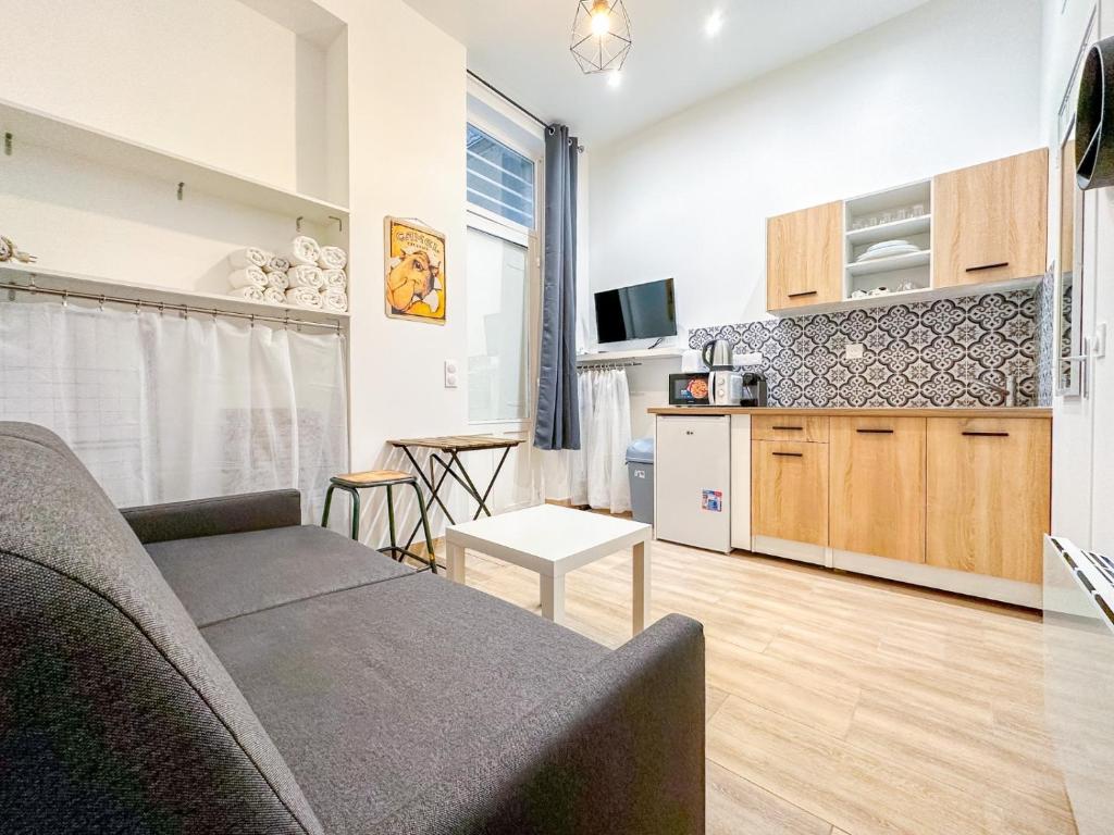 un salon avec un canapé et une cuisine dans l'établissement Marais - Canal st Martin 20m2, à Paris
