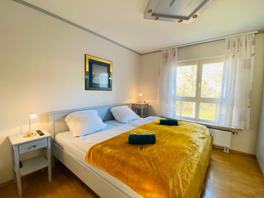 a bedroom with a large bed with a yellow blanket at Idyllisches Ansbacher Apartment 1 Stock mit Aufzug in Ansbach