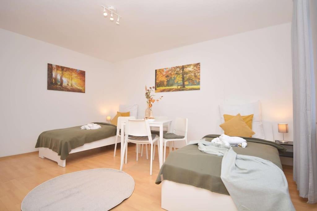 a room with two beds and a table with a tableablish at KU-02RI Apartment in Kulmbach OG in Kulmbach