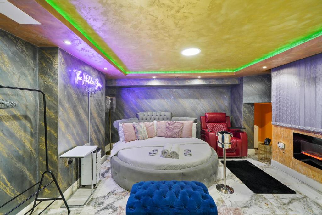 1 dormitorio con 1 cama grande en una habitación con paredes moradas en Hidden Gem Lt Properties Jaccuzi bath massage chair Superkingsize bed Parking available, en Luton