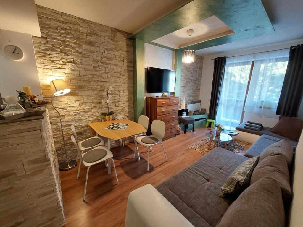 a living room with a couch and a table at Cozy family apartment with garage in Donovaly