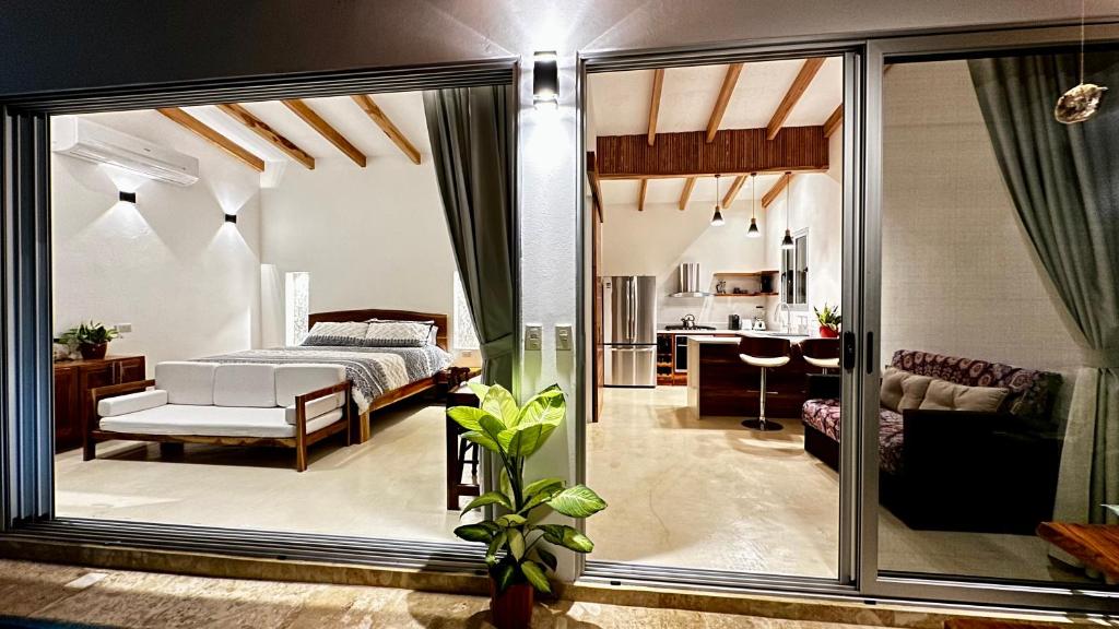 a bedroom with a bed and a living room at Villas Paraiso Azul in Santa Teresa Beach