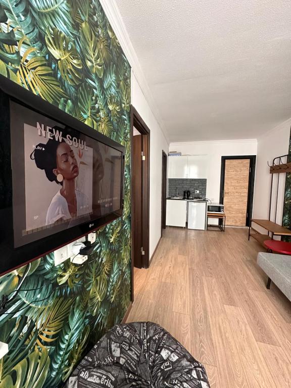 グダウリにあるThea's Apartmentの壁に薄型テレビが取り付けられたリビングルーム