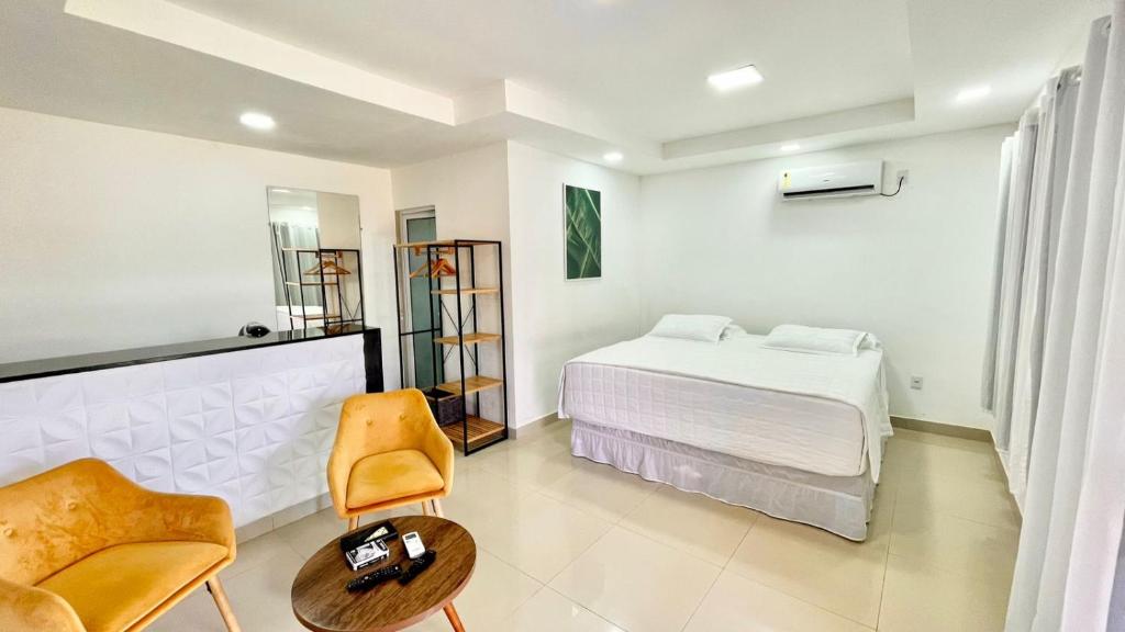 ein Schlafzimmer mit einem Bett, einem Stuhl und einem Tisch in der Unterkunft Terras Verdes Residence in Fernando de Noronha