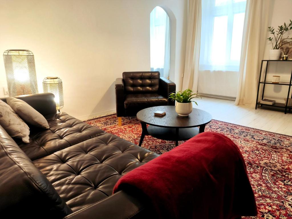 a living room with a leather couch and a table at CozyHome Signature Palisady Apartment in Bratislava