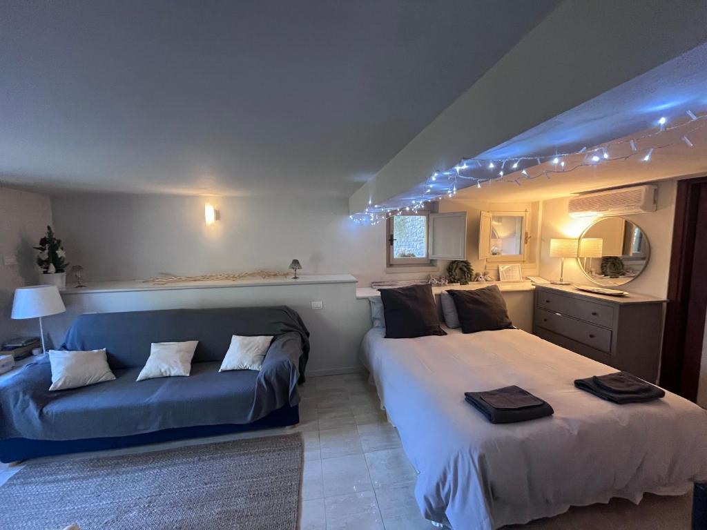 a bedroom with two beds and a blue couch at la casetta di anita in toscana arezzo in Arezzo