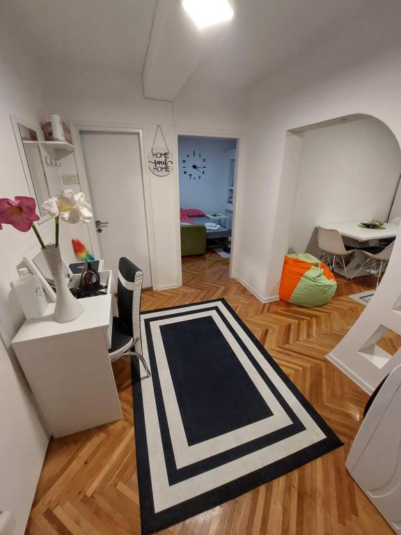 sala de estar con alfombra blanca y negra en el suelo de madera en Apartman Stil, en Višegrad