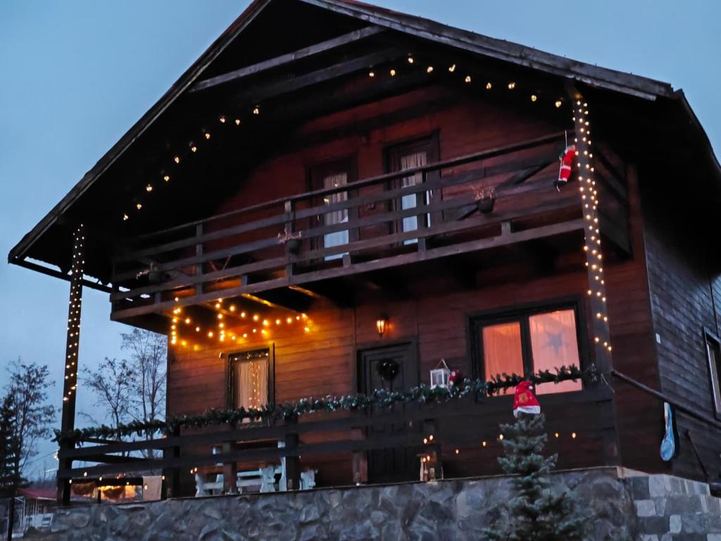 コバスナにあるThe Wooden Nest -Covasnaのクリスマスライト付きのログキャビン
