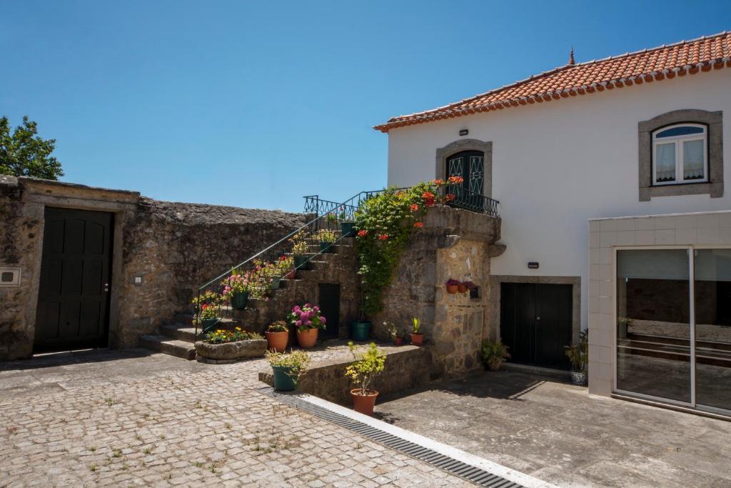 una casa blanca con macetas en las escaleras en Casa Praia e Campo, en Viana do Castelo