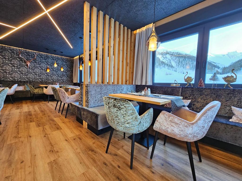 a restaurant with a table and chairs with a view at Chasa Castello relax & spa in Samnaun