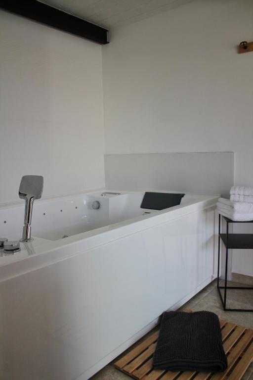 a white counter with a sink and a stool at Gîte spa la parenthèse in Sauve