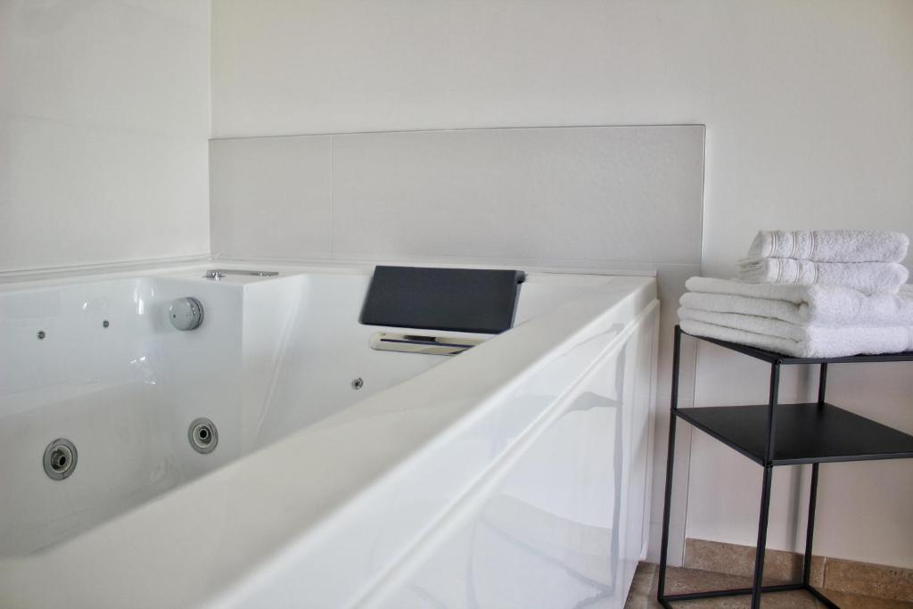 a bathroom with a bath tub with a laptop on it at Gîte spa la parenthèse in Sauve