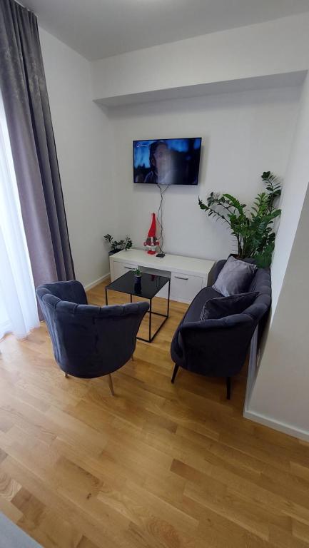 ein Wohnzimmer mit 2 Stühlen und einem Tisch in der Unterkunft Studio Apartment Smile Mostar in Mostar