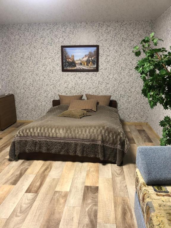una camera da letto con un letto grande con pavimento in legno di Квартира Пентагон a Korostenʼ