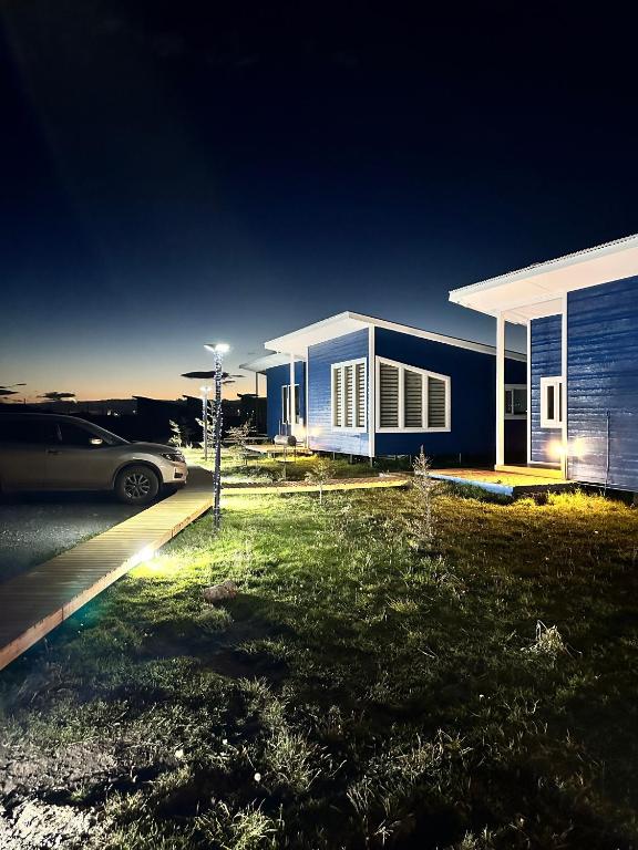 a blue house with a car parked in front of it at Cabañas Arte Brisa Patagonia in Puerto Natales