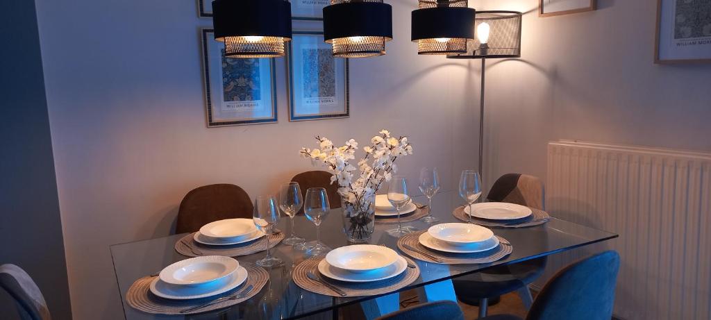 a dining room table with plates and glasses and a vase of flowers at Casa Rotella in Puente San Miguel