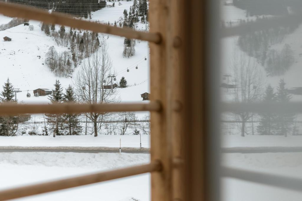 Blick auf einen schneebedeckten Berg aus dem Fenster in der Unterkunft FRÄULEIN NANNERL - Boutique Aparthotel in Gerlos