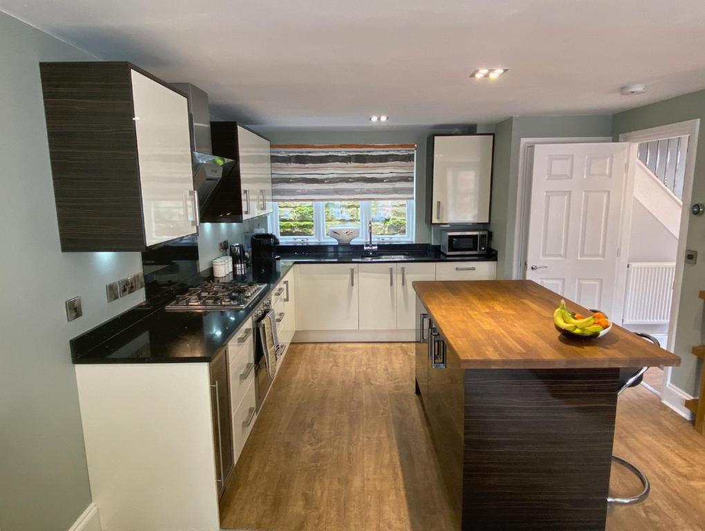 a kitchen with white cabinets and a wooden counter top at Luxury Home With Stunning River Views in Knaresborough