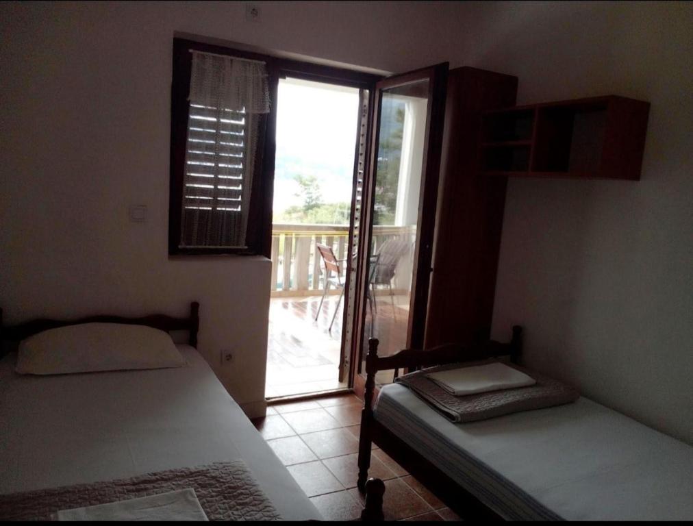 a bedroom with two beds and a door to a balcony at Apartment Željka, Igalo - Herceg Novi in Igalo