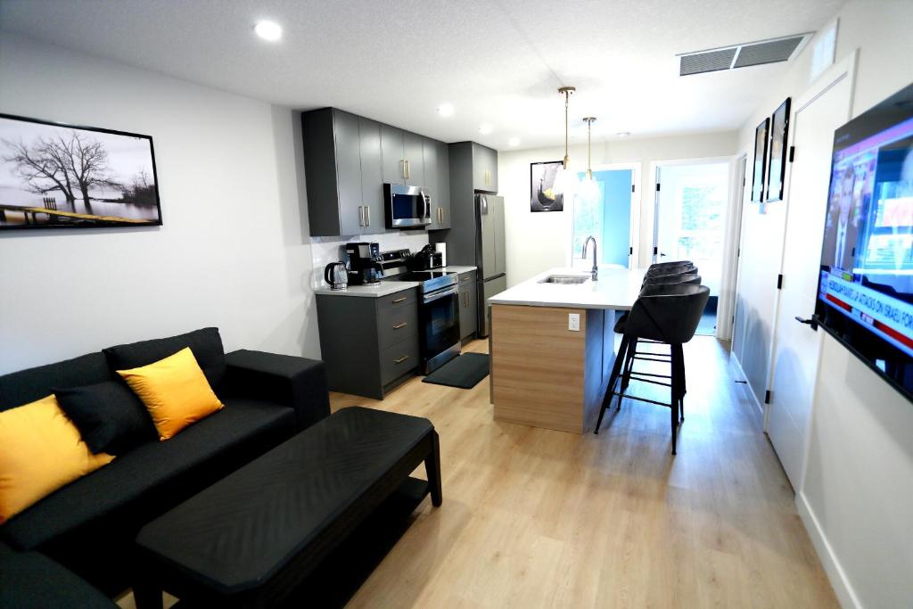 uma pequena sala de estar com um sofá e uma cozinha em Mountain Retreat: Brand New 2BR Condo em Canmore