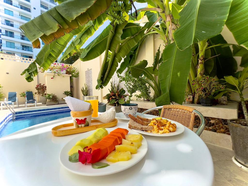 une table avec deux assiettes de nourriture dans l'établissement Charme 64 Hotel Boutique, à Carthagène des Indes